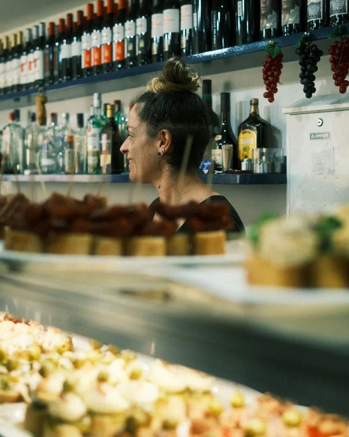 Camarera tras la barra de pinchos de un bar