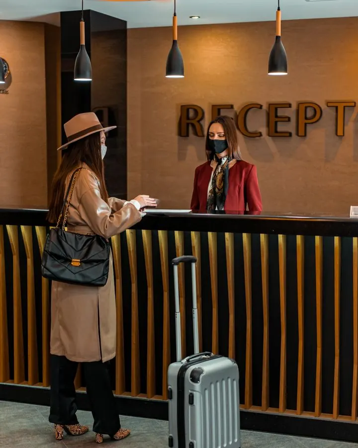 Huésped registrándose en la recepción de un hotel